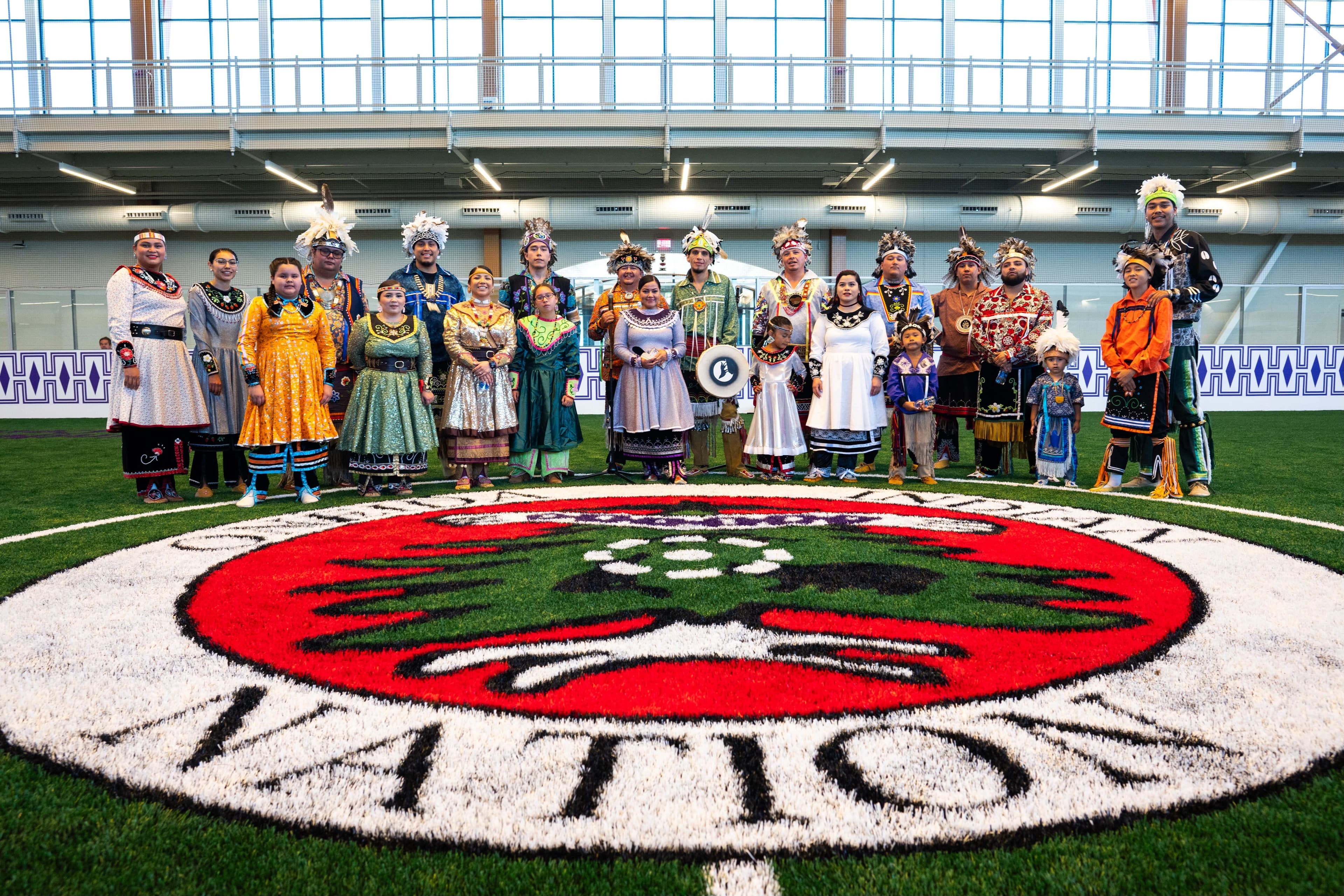 Nation members at center logo on turf